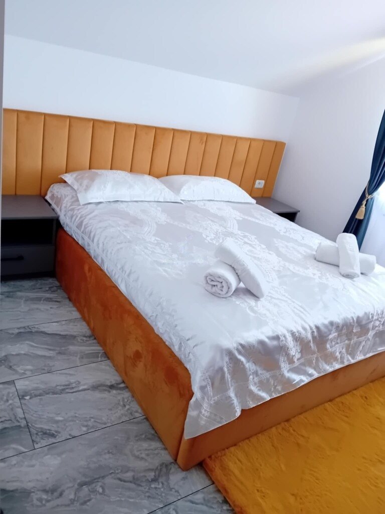 Apartament – dormitor cu pat din lemn